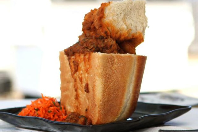 Bunny chow on a plate with salads